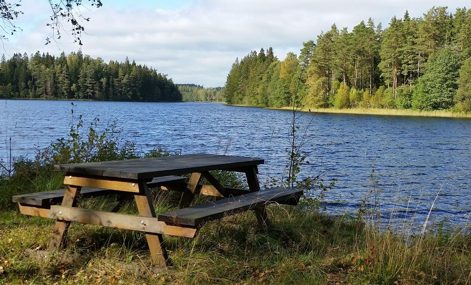 Rastplats med träbänk vid sjö längs Pilgrimsleden Kindaholm.