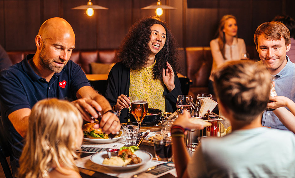 Glada människor äter på restaurangen.